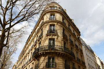 Fototapeta na wymiar The facade of traditional French house with typical balconies and windows. Paris.