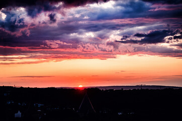 A radiant sunset paints a dramatic scene across the sky, showcasing a striking interplay of light...