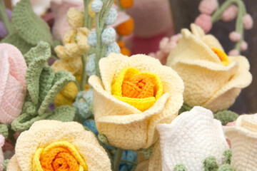 Close up on bouquet of beautiful hand crafted crochet flowers. Yellow and orange roses