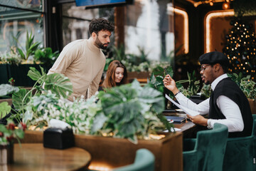 A focused group of teammates engaged in a business meeting at a restaurant adorned with Christmas decorations, highlighting a collaborative work atmosphere.