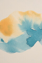 Ink watercolor hand drawn pour flow painting smear brushstroke blot. Wave blue, yellow beige wall grain texture background.
