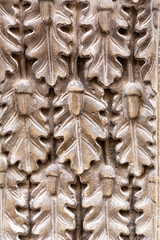 Detail from a wall ornament with oak leaves and acord carved on stone