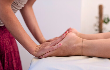 Foot massage and feet therapy of woman in spa salon. Pedicure and reflexology of body. Close up.