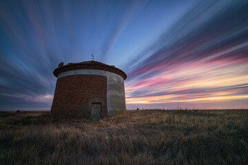 Sunset with intensely colored clouds over the Ledigos dovecote, Tierra de Campos, Palencia in...