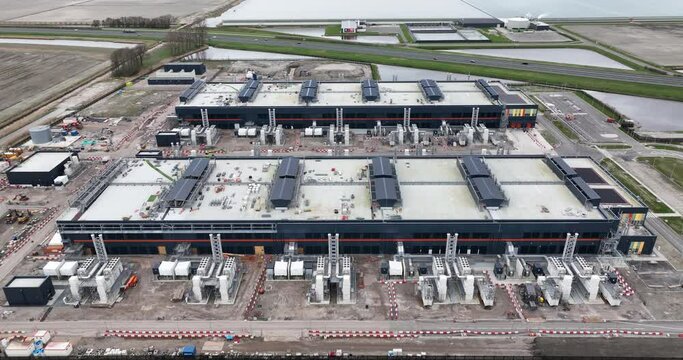Aerial drone view of a large datacenter under construction, internet infrastructure building at Agriport, The Netherlands. Computing and internet data structure. Birds eye view.