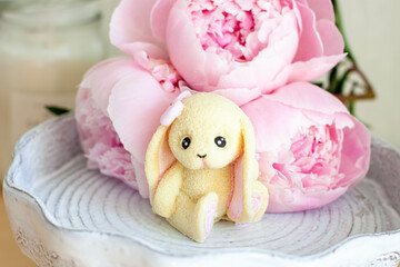 Fototapeta na wymiar Cute edible bunny made of white chocolate with peony flowers and candles
