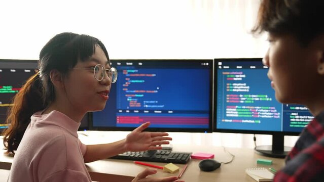 Slow motion back end software developer engineer for computer programming working together on debugging writing computing code, solving complex algorithms display on monitor in office. Burgeoning