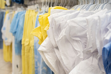 women's or girl's clothing in light pastel colors on hangers in a store, close-up.