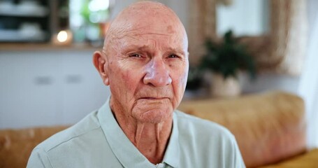 Mature, senior man and face while sad, indoor and depression in house, lounge and living room. Elderly man, mourning and widower with sorrow, despair and lonely on a couch, sofa and retirement home
