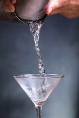 Pouring chilled gin into a martini glass