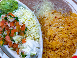 Mexican fried rice, refried beans, and a tray of fajita fixings