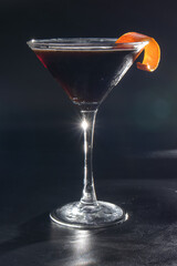 A martini glass with a slice of orange on top