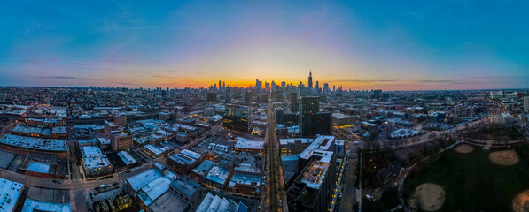 A panoramic view of the cityscape of Chicago at dusk, where the golden hues of the sunset paint a...