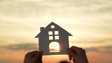 hands holding paper house, window sunset ray, happy family mortgage build new house, refinancing...