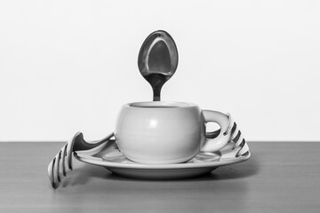 Taza de café con cuchara y tenedores en blanco y negro