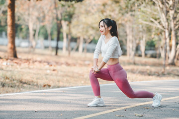 Fototapeta na wymiar Active young woman stretching during an outdoor workout session in a park, showcasing a healthy lifestyle and fitness routine.