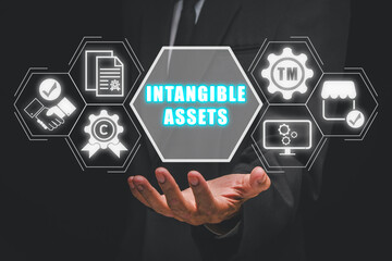 Intagible assets concept, Businessman hand holding intagible assets icon on virtual screen.