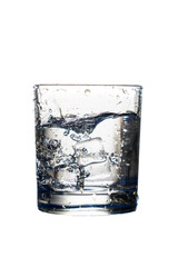 Glass of water with ice cubes falling inside