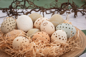 Naklejka na ściany i meble Easter decorative eggs in a basket nest with straw background
