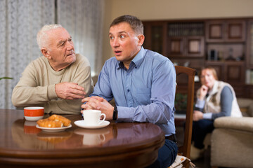 Adult man spending time with his senior parents at home