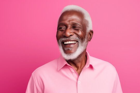 Close up studio portrait of handsome black man against pink background.