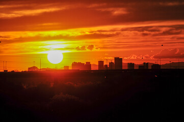 The intense sunlight of a sunset outlines the skyline of downtown Phoenix, Arizona, known as the...