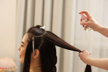 Naklejka premium Hair styling. Professional hairdresser working with client in salon, closeup