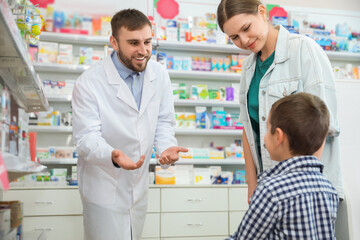 Fototapeta na wymiar Professional pharmacist working with customer in modern drugstore