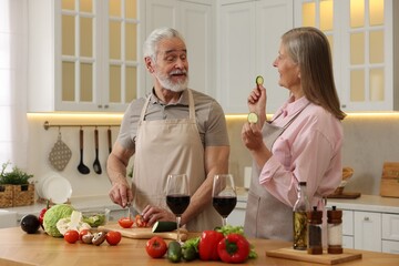 Obraz na płótnie Canvas Happy senior couple cooking together in kitchen