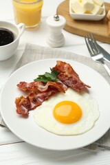 Delicious breakfast with sunny side up egg served on white wooden table