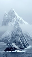 Snowy Mountain Peaks Rising Above Ocean with Misty Atmosphere Creating a Mysterious Landscape