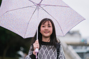 傘を差す小学生の女の子のクローズアップ