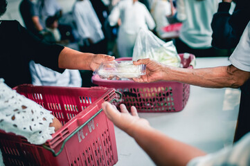 Poor people receive donated food from donors: The hands of the poor receive food from the hands of...