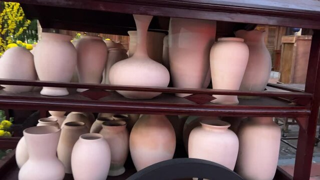 A lot of made clay or white ceramic vases, jugs and utensils at the stand of the ceramics factory. Ceramic dishes not yet painted just from the oven. High quality 4k footage