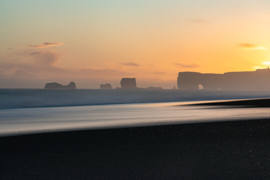 The view of Dyrhólaey Peninsula from Reinisfjara beach in south Iceland during colorful sunset