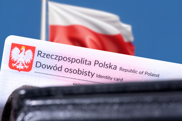 Close-up of Polish identity card and Polish flag in the background