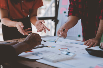 Fototapeta premium Financial analyst analyzes business finance reports on laptop and graph documents during corporate meeting discussions showing successful teamwork, business meeting ideas, marketing.