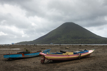 Small fishermam boats and Gunung Api volcano in Bandaneira island, Banda islands, Maluku at low tide