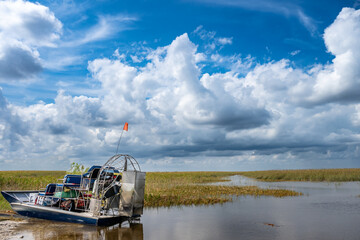 Docked airboat in the everglades of Florida with grass and wetland swamp in the background