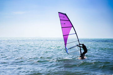 Windsurfers enjoy riding the waves during the sunny summer months