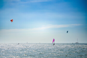 Windsurfers enjoy riding the waves during the sunny summer months
