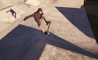 Skateboard, jump or man with ramp, challenge or training for a competition, hobby or sunshine....