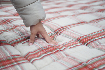 women Hand touching and pressing orthopedic mattress on bed.