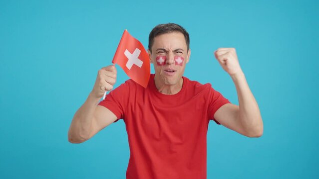Man cheering for Switzerland screaming and waving a national flag