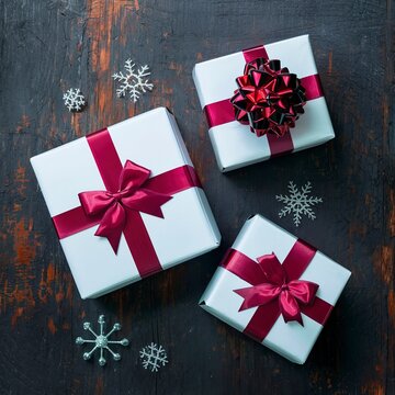 White Christmas gift boxes with red bows. On a dark rustic background