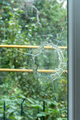 Fototapeta na wymiar Window glass broken by a stone in a house