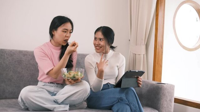 Two female friends spend their weekends together doing various activities together at home, Two sisters happily spend family time doing activities together at their home.