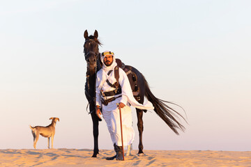 Saudi man in a desert with his horse