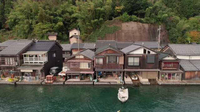 Aerial panoramic Drone of Boathouses at Japanese Kyotango Coastline Beach Houses in Japan Summer Travel Destination