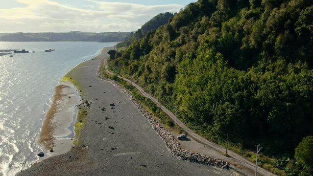 Aerial view following the coastline of Tenaun, golden hour in Chiloe, Chile